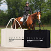 a person riding a horse in a field, with two bags labeled "Equestrian" in the foreground.