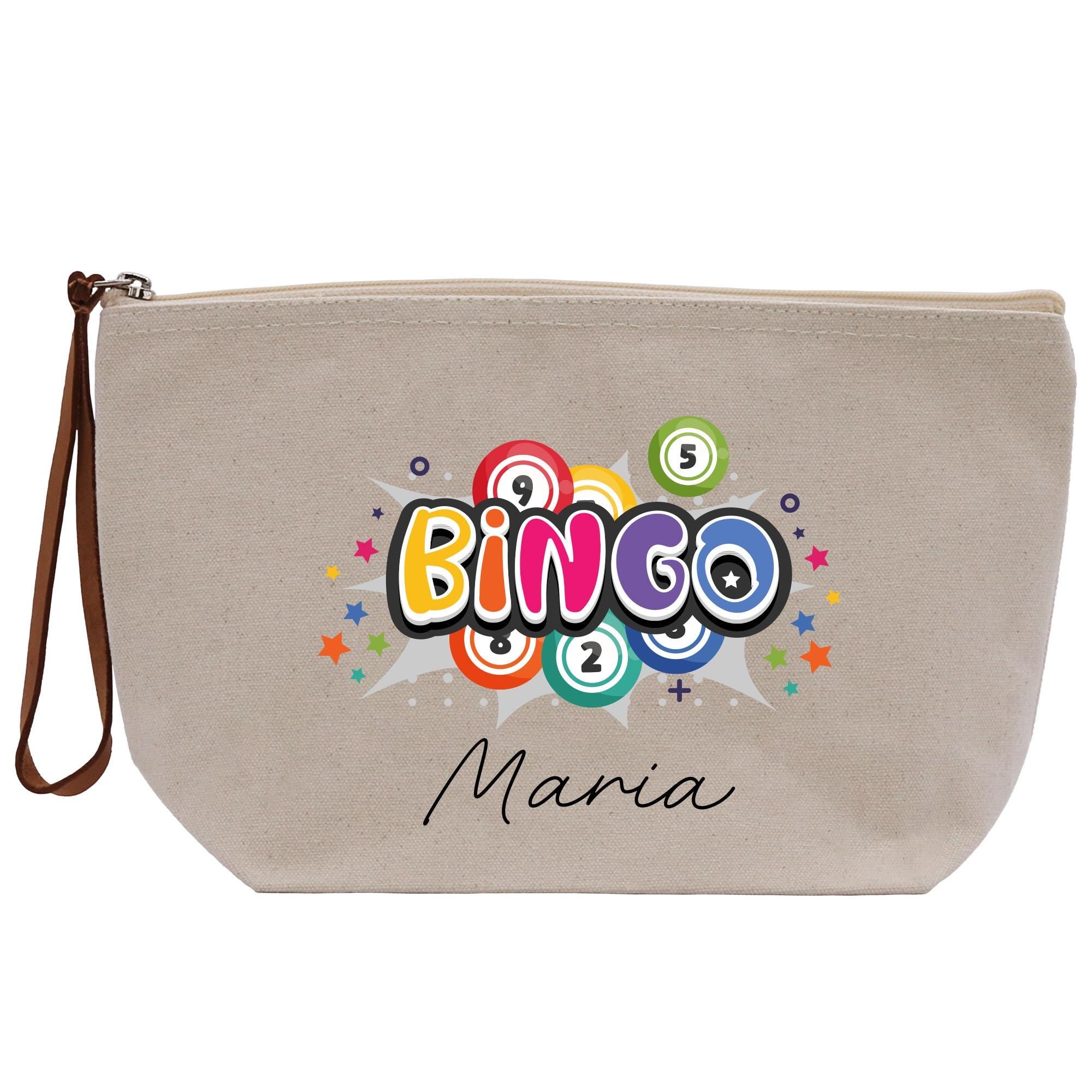 A beige canvas tote bag with a colorful graphic design featuring the word &quot;BINGO&quot; surrounded by various shapes and patterns, including stars, circles, and a burst effect.