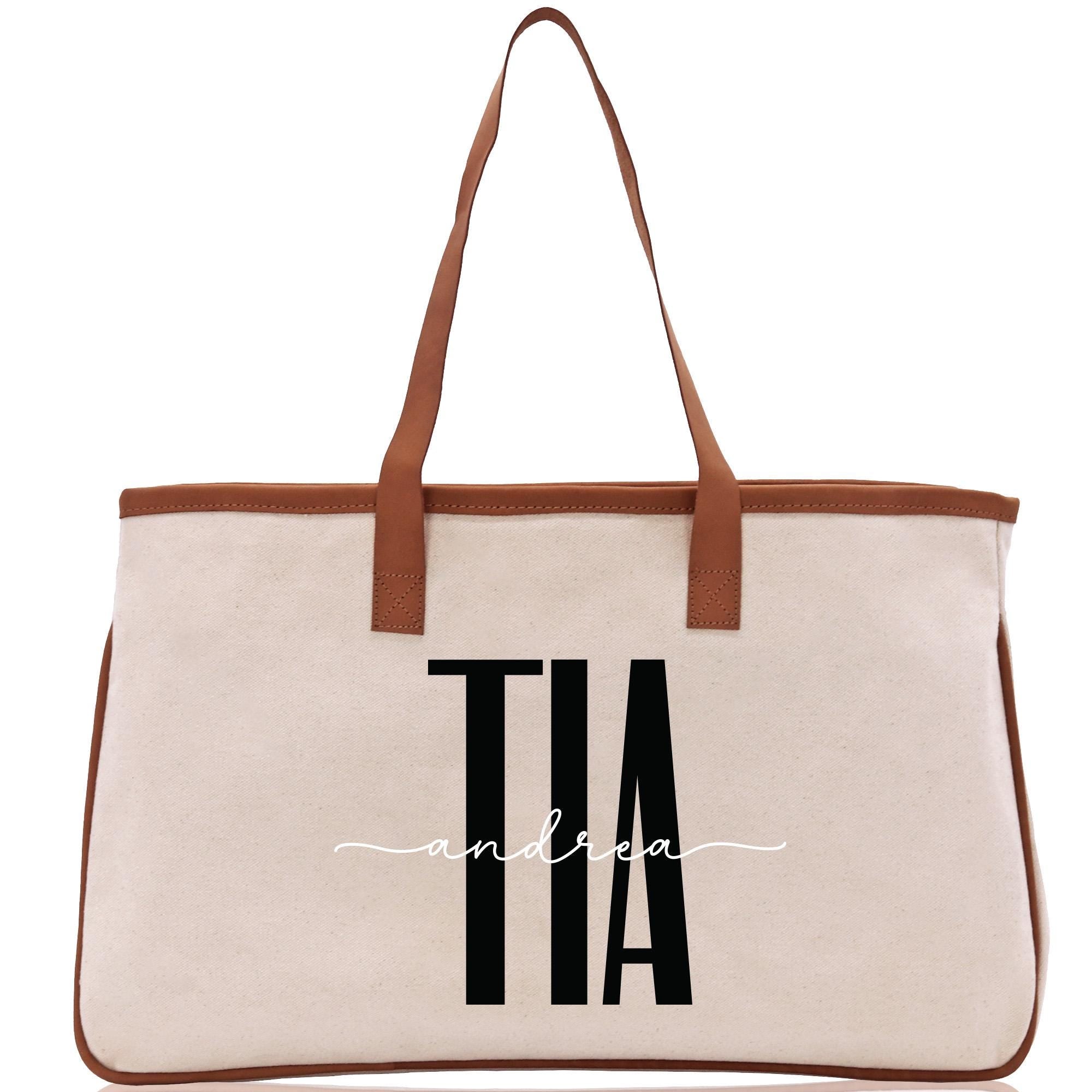 a canvas tote bag with a brown leather handle