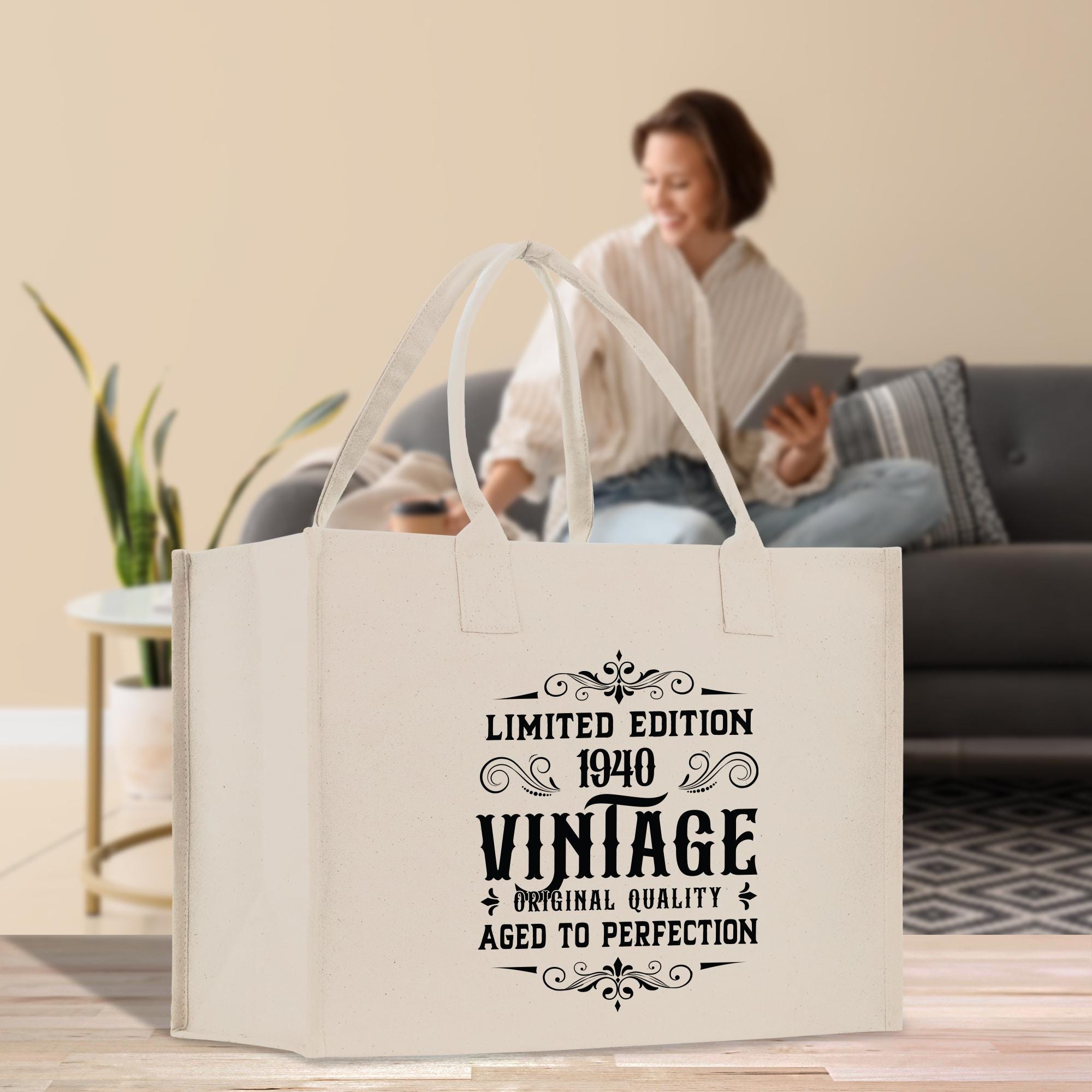 A white tote bag with a vintage-style design, featuring text that reads "Limited Edition 1940 VINTAGE ORIGINAL QUALITY AGED TO PERFECTION".