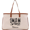 a white canvas bag with a brown leather handle