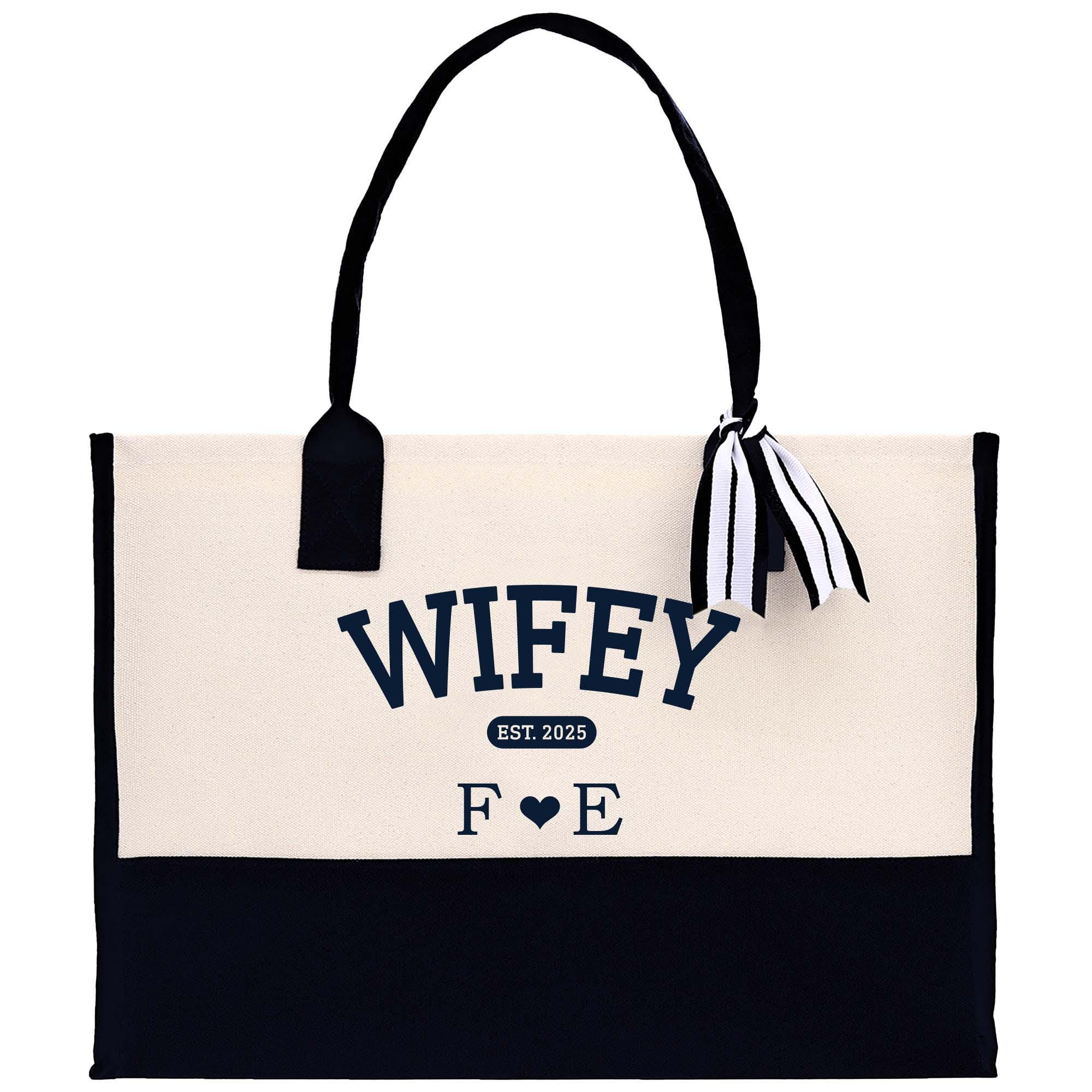 a white and black bag with a bow on it