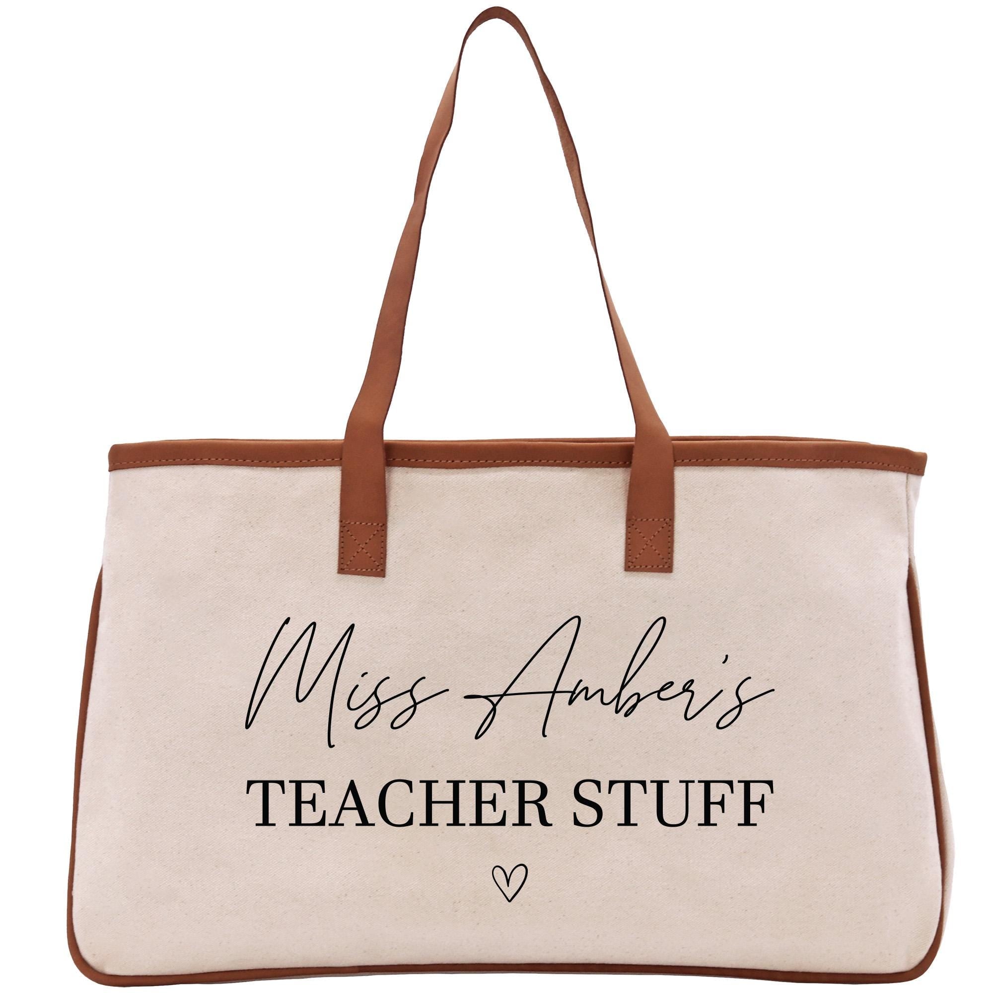 a white canvas bag with a brown leather handle