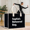 a woman in a black dress is dancing with a black and white shopping bag