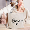 a woman sitting at a table with a dog in front of her