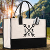 A black and white tote bag with a graphic design on it, placed on a wooden surface with a natural outdoor background.