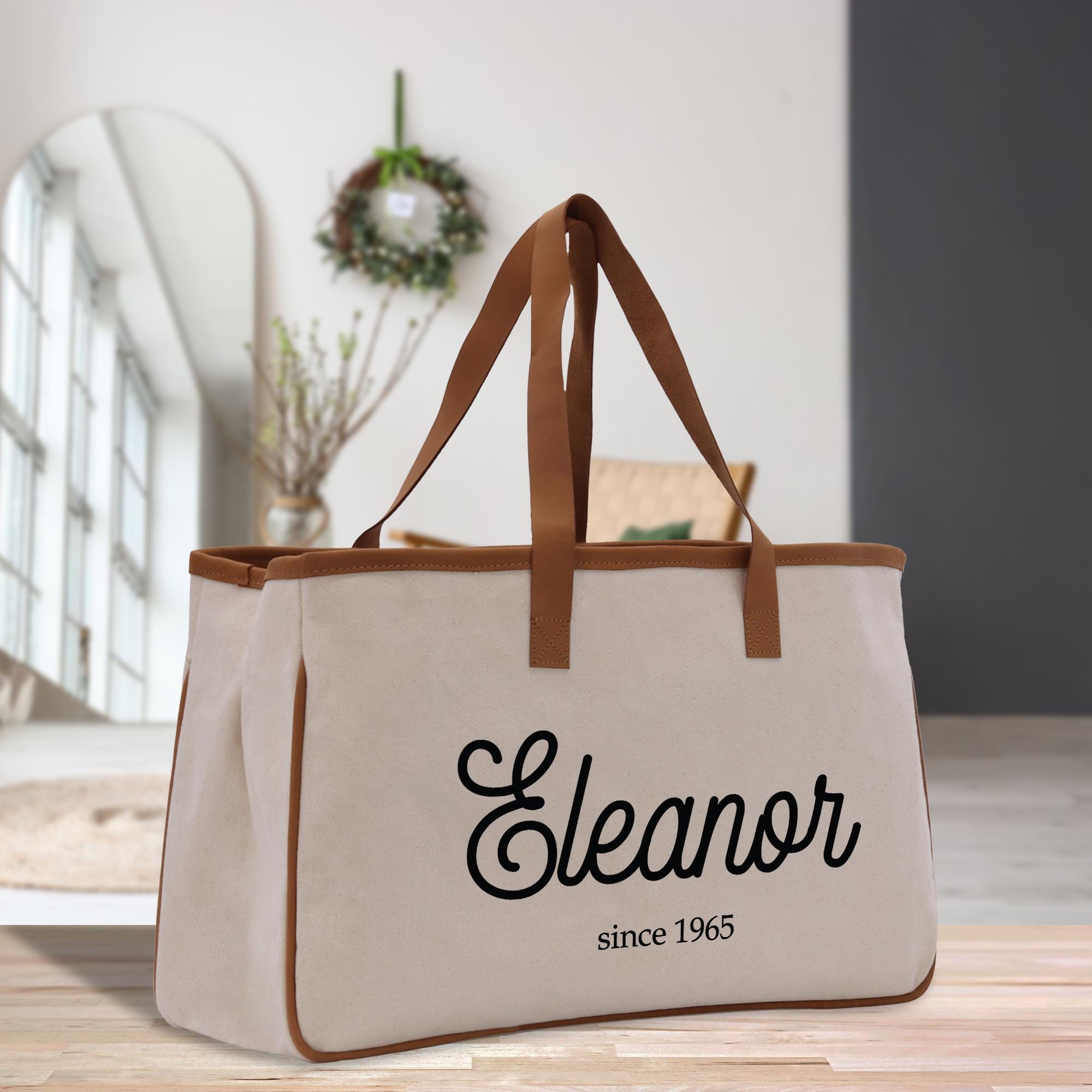 a canvas tote bag with a leather handle