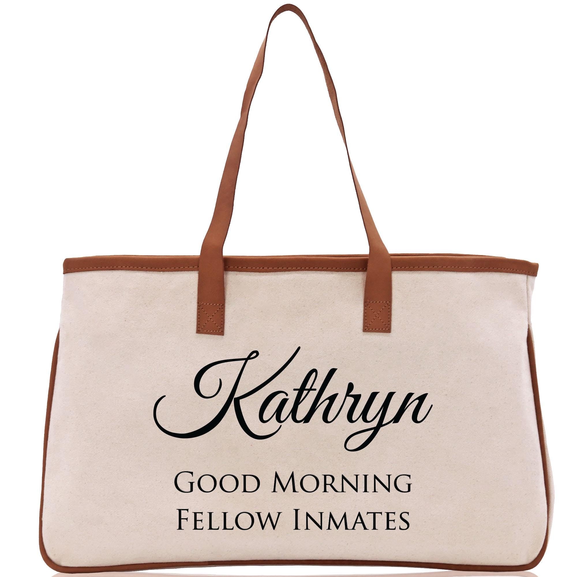 a white bag with brown handles and a brown handle