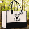 A white tote bag with a black and white graphic design on it, featuring the text 