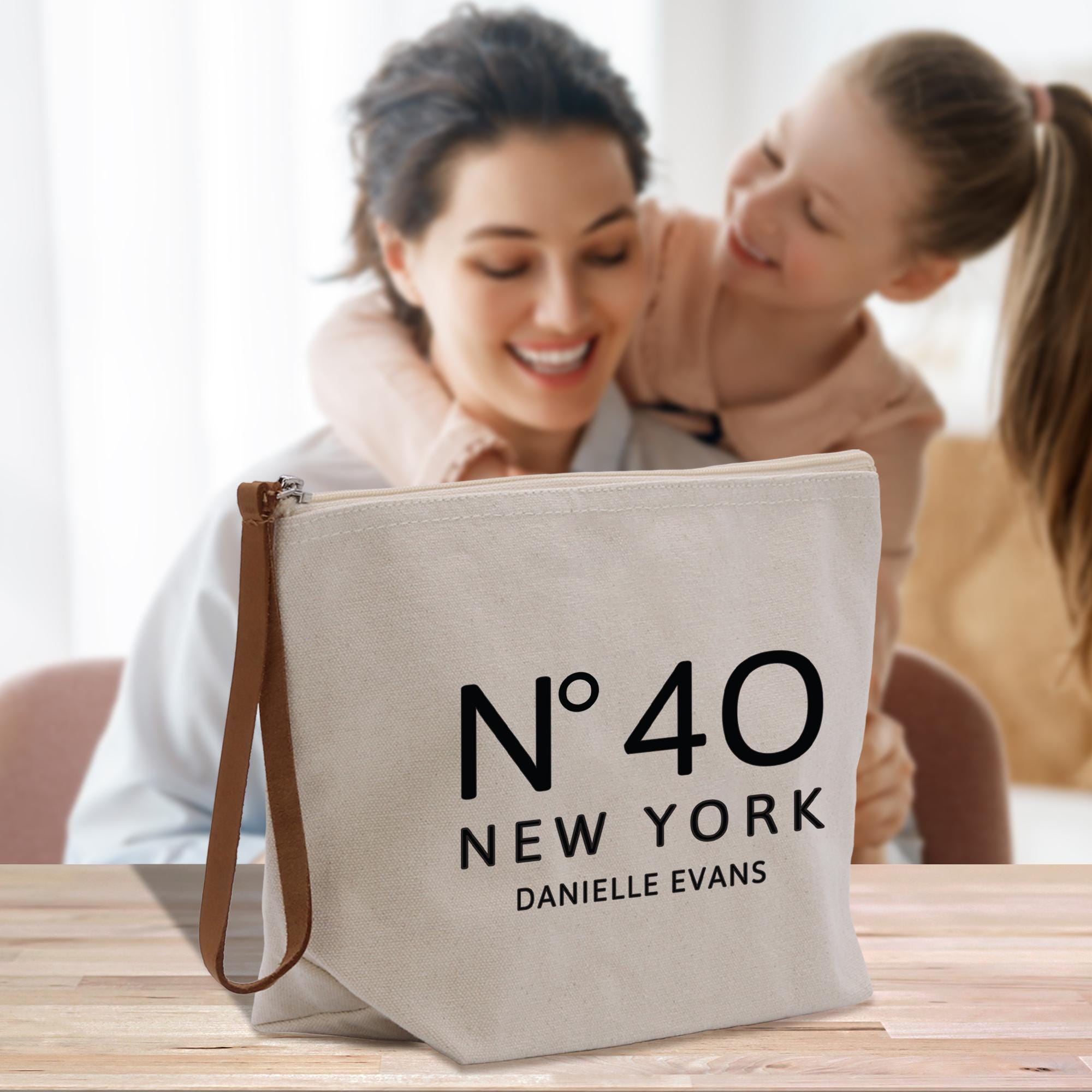 a woman and a girl are looking at a new york tote bag