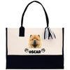 A tote bag with a chow dog image printed on it, and the name "OSCAR" printed below the dog's head.