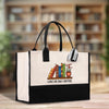 A white tote bag with a black handle and straps, featuring a graphic of books and a plant, and the text "I HAVE NO SHELF CONTROL" printed on it.