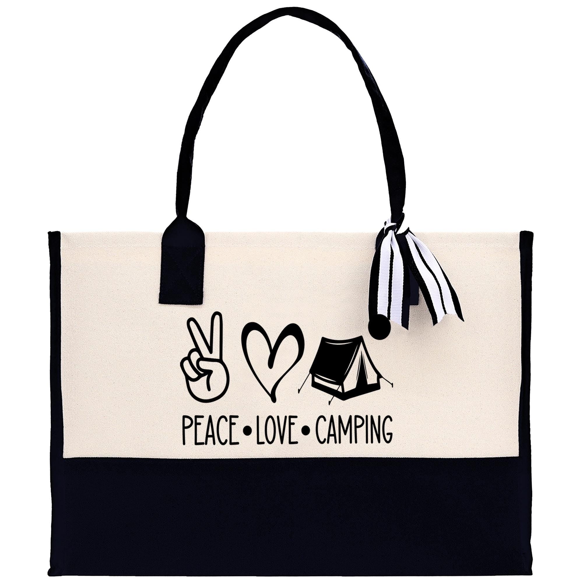 A beige tote bag with a black handle and strap, featuring a printed design that says "PEACE. LOVE. CAMPING" along with a peace sign, a heart, and a tent.