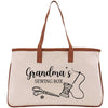 A beige tote bag with a brown handle and a printed design that says "Grandma's Sewing Box" along with illustrations of sewing tools.