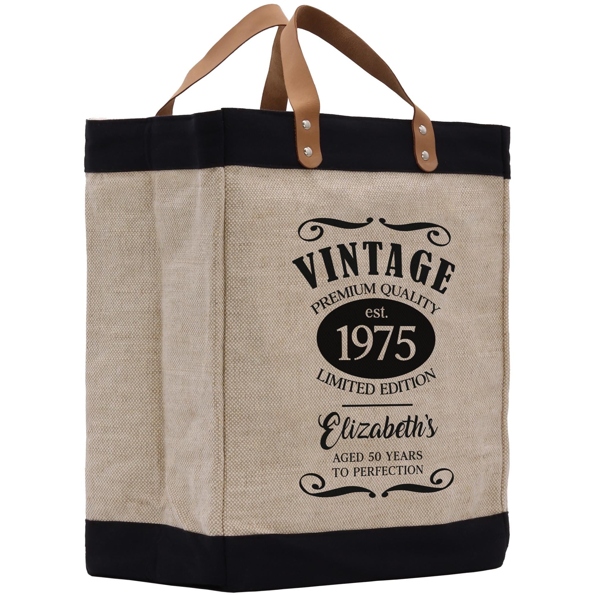 A beige tote bag with a black trim and leather handles, featuring a vintage-style design with text and graphics.