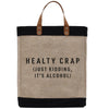A beige tote bag with black trim and leather handles, displaying the text "HEALTHY CRAP [JUST KIDDING, IT'S ALCOHOL]" printed on it.