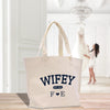 a white tote bag sitting on top of a wooden table