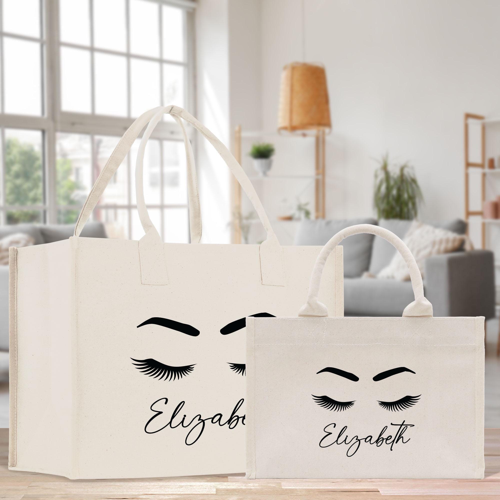 two bags with eyelashes on them sitting on a table