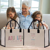 a woman and two girls sitting on a couch with a shopping bag