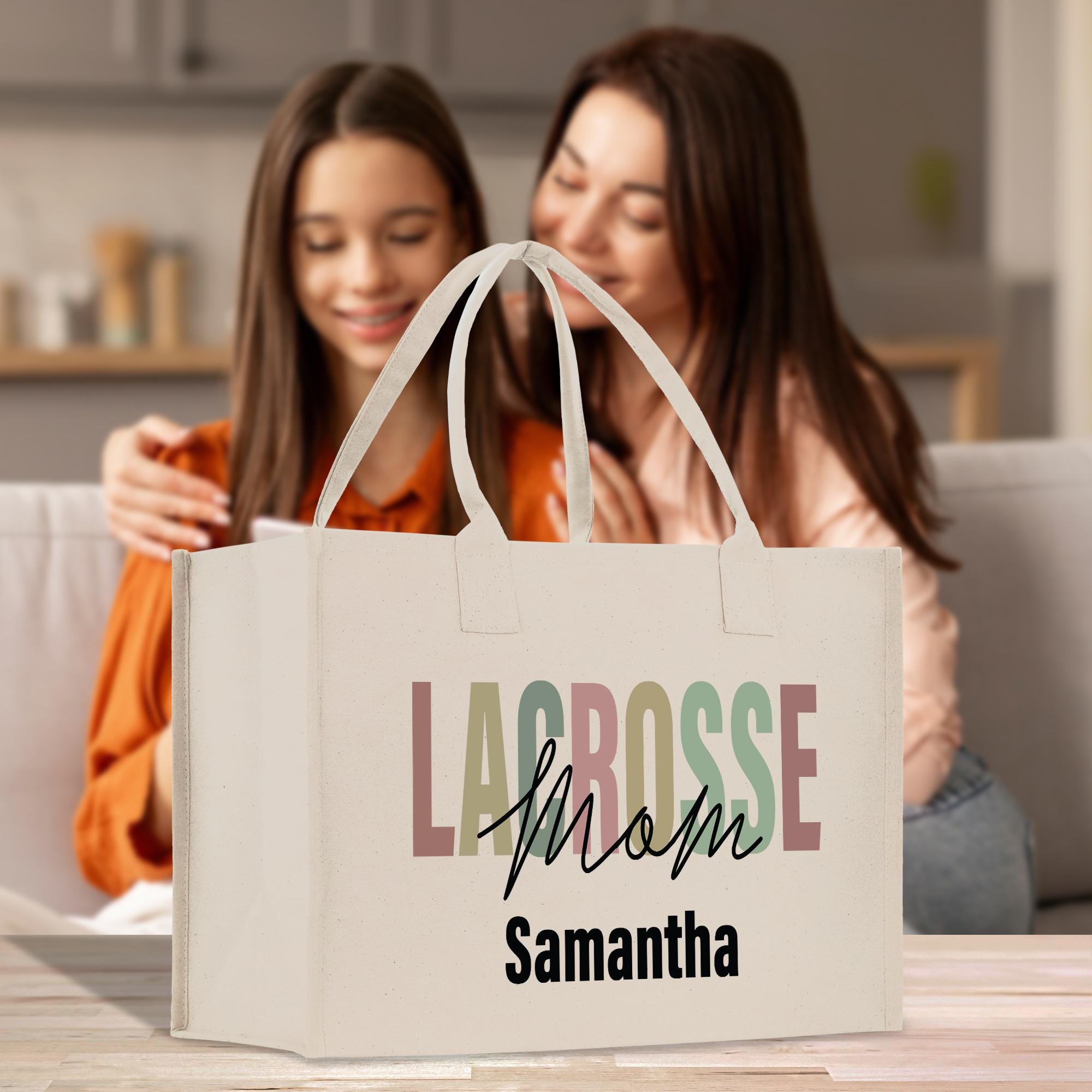 two women sitting on a couch looking at a bag