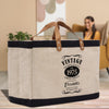 A beige tote bag with a black handle and straps, featuring a vintage-style design and text that reads "VINTAGE PREMIUM QUALITY EST. 1975 LIMITED EDITION Elizabeth's 50 YEARS TO PERFECTION".