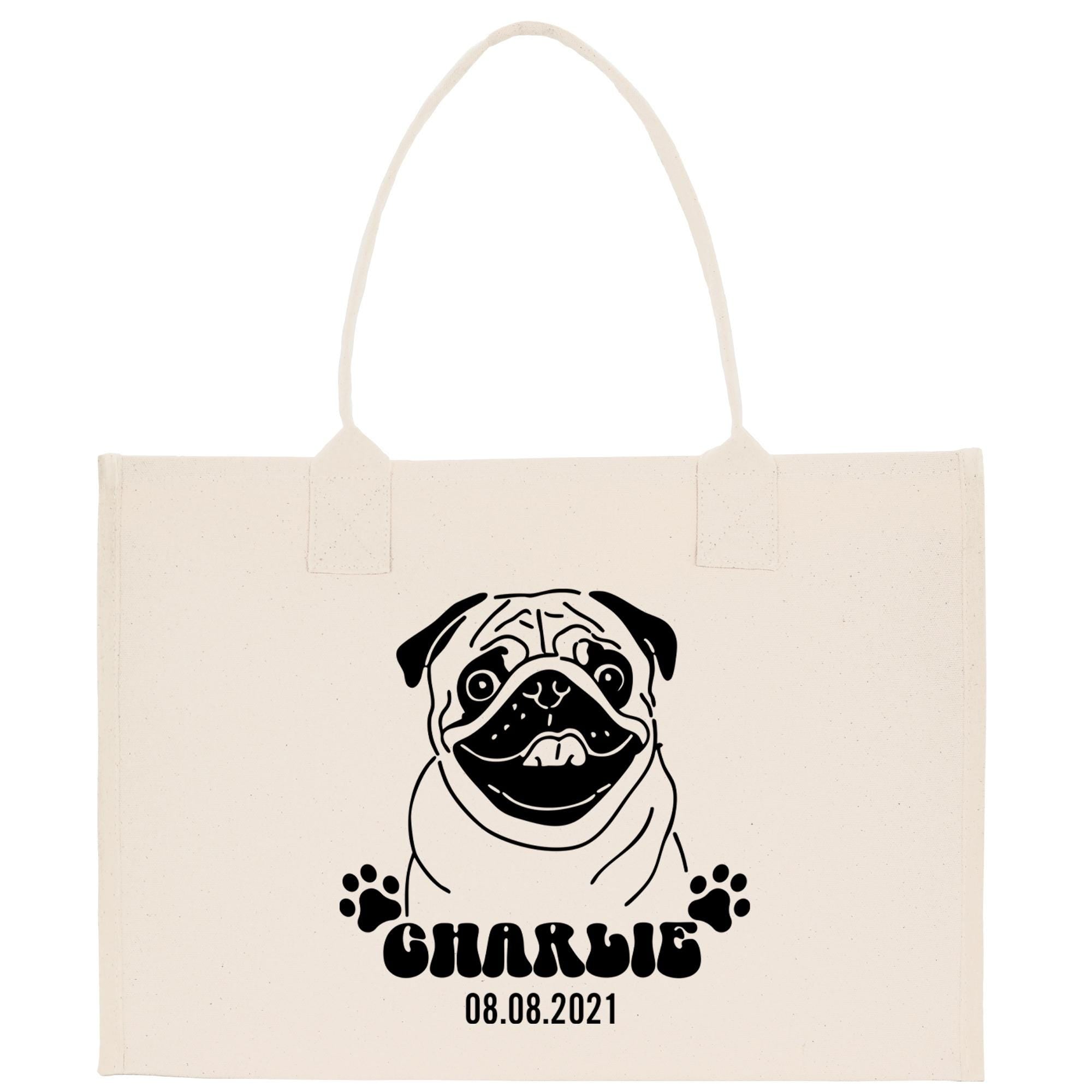 A beige canvas tote bag with a black and white illustration of a pug dog and the text &quot;Charlie 08.08.2021&quot; printed on it.