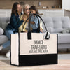 two women sitting on a couch with a black and white bag