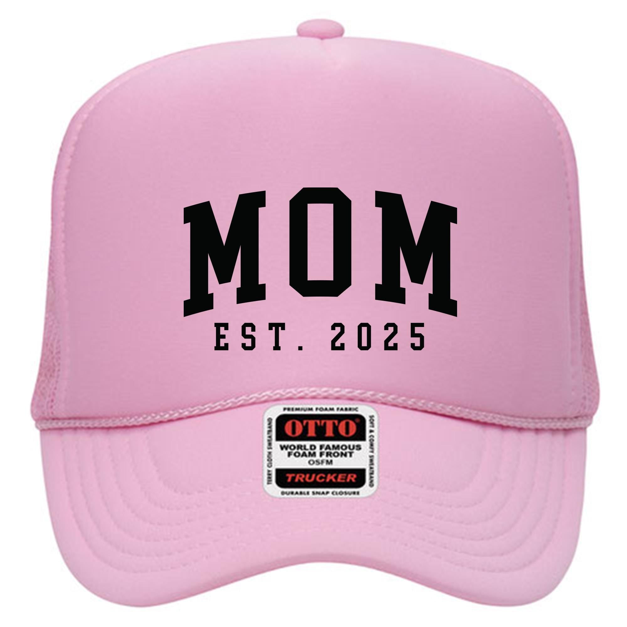 A pink baseball cap with the text &quot;MOM EST. 2025&quot; printed on it.