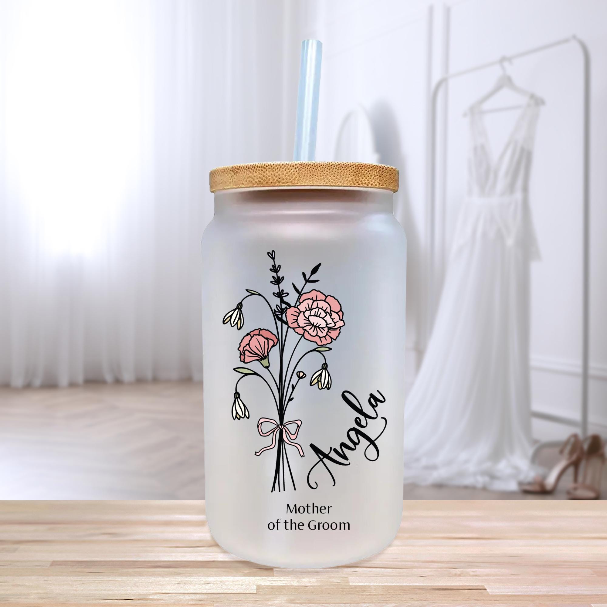 a glass jar with a straw lid and a flower design