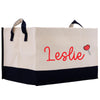 A beige and black tote bag with the name "Leslie" printed on it in red cursive text.