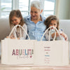 a woman and two girls sitting on a couch with shopping bags
