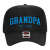 A black baseball cap with the text "GRANDPA EST. 2025" printed on it in blue letters.