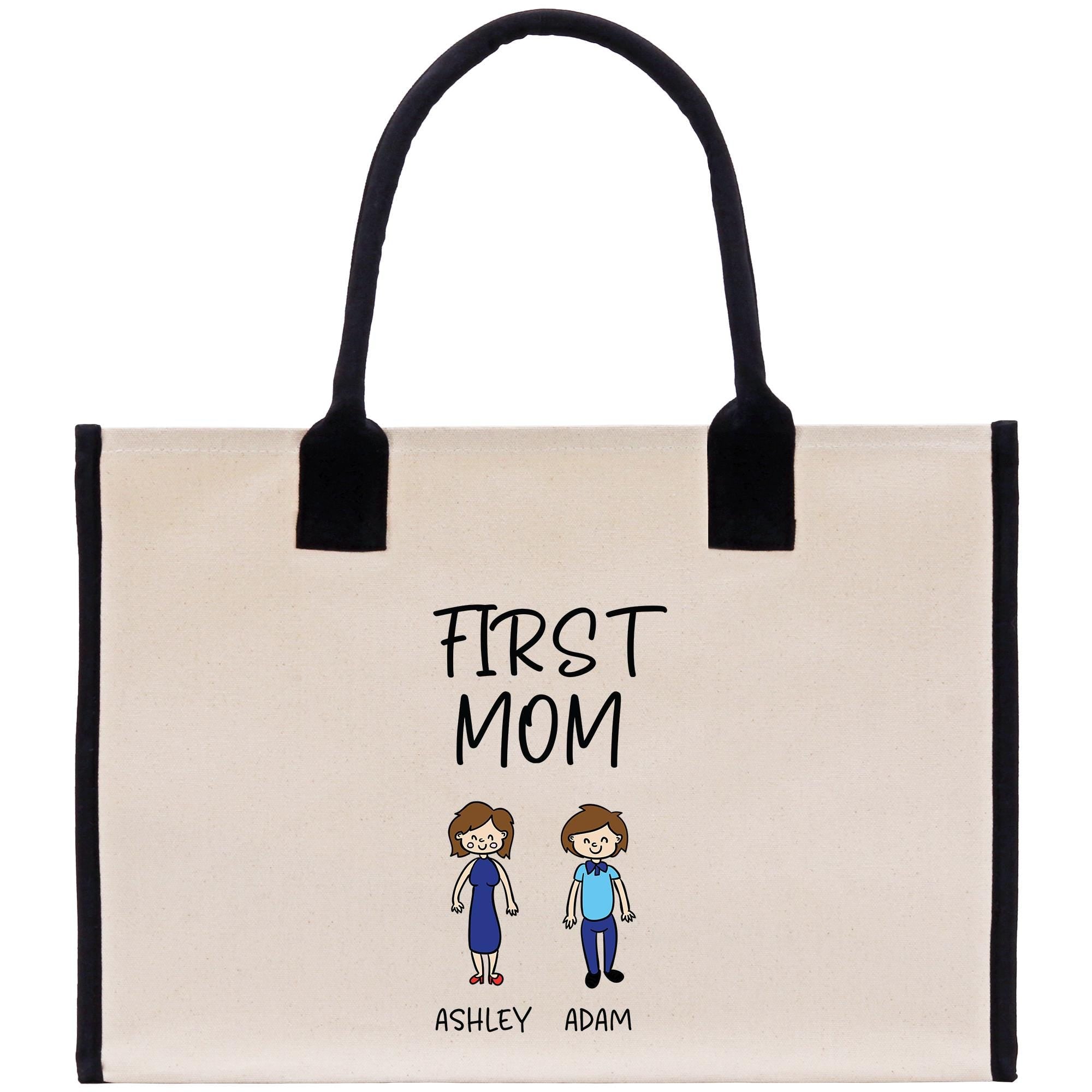 A beige tote bag with a black handle and a printed design on the front. The design features two cartoon-style figures, one male and one female, along with the text &quot;FIRST MOM&quot; and the names &quot;ASHLEY ADAM&quot;.