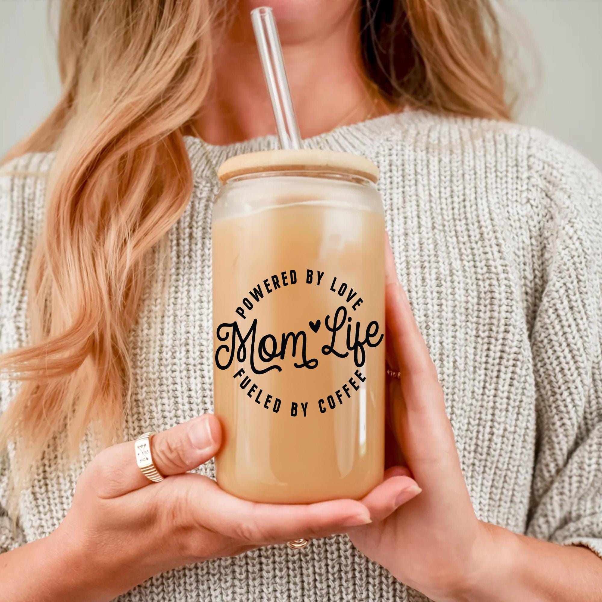 a woman holding a drink with a straw in her hand