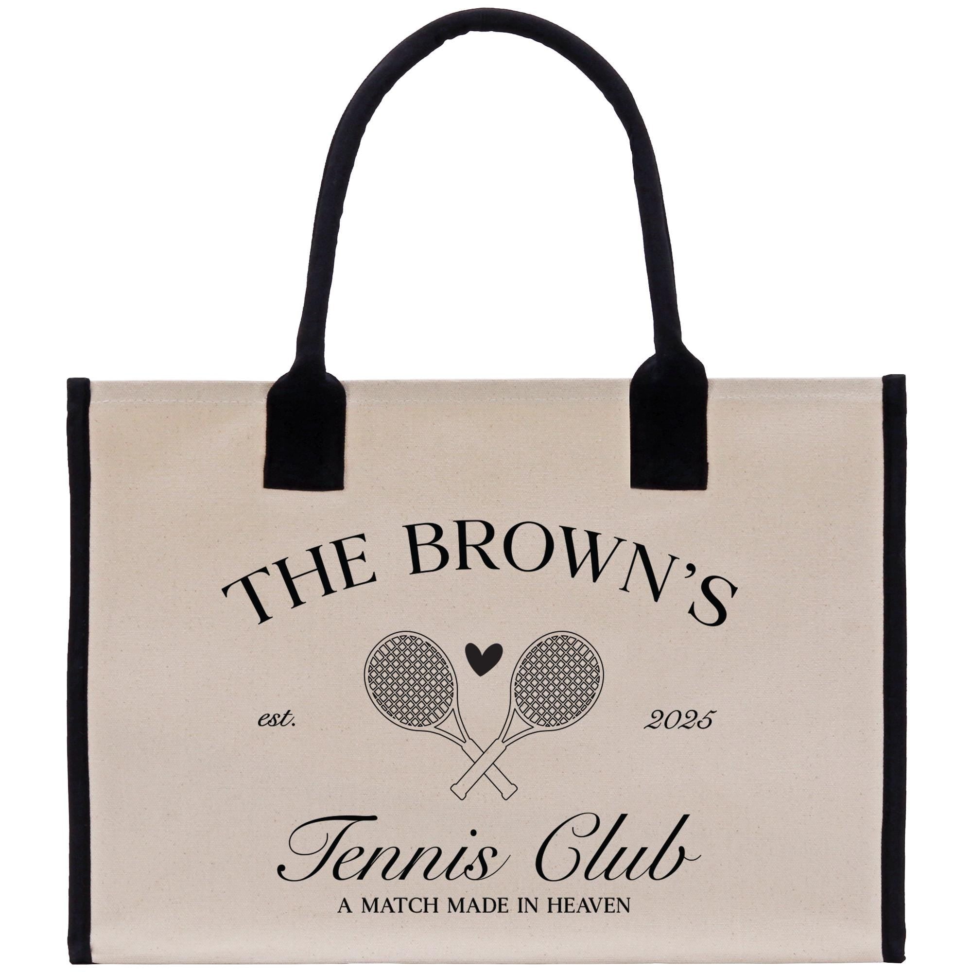 The image is a tote bag with a black handle and a beige background. It features a logo for &quot;The Brown&#39;s Tennis Club&quot; and includes tennis rackets and a heart symbol.