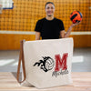 a man holding a volleyball ball and a tote bag