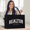 a woman holding a black bag with the word realtor on it