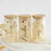 three jars filled with white flowers on top of a table