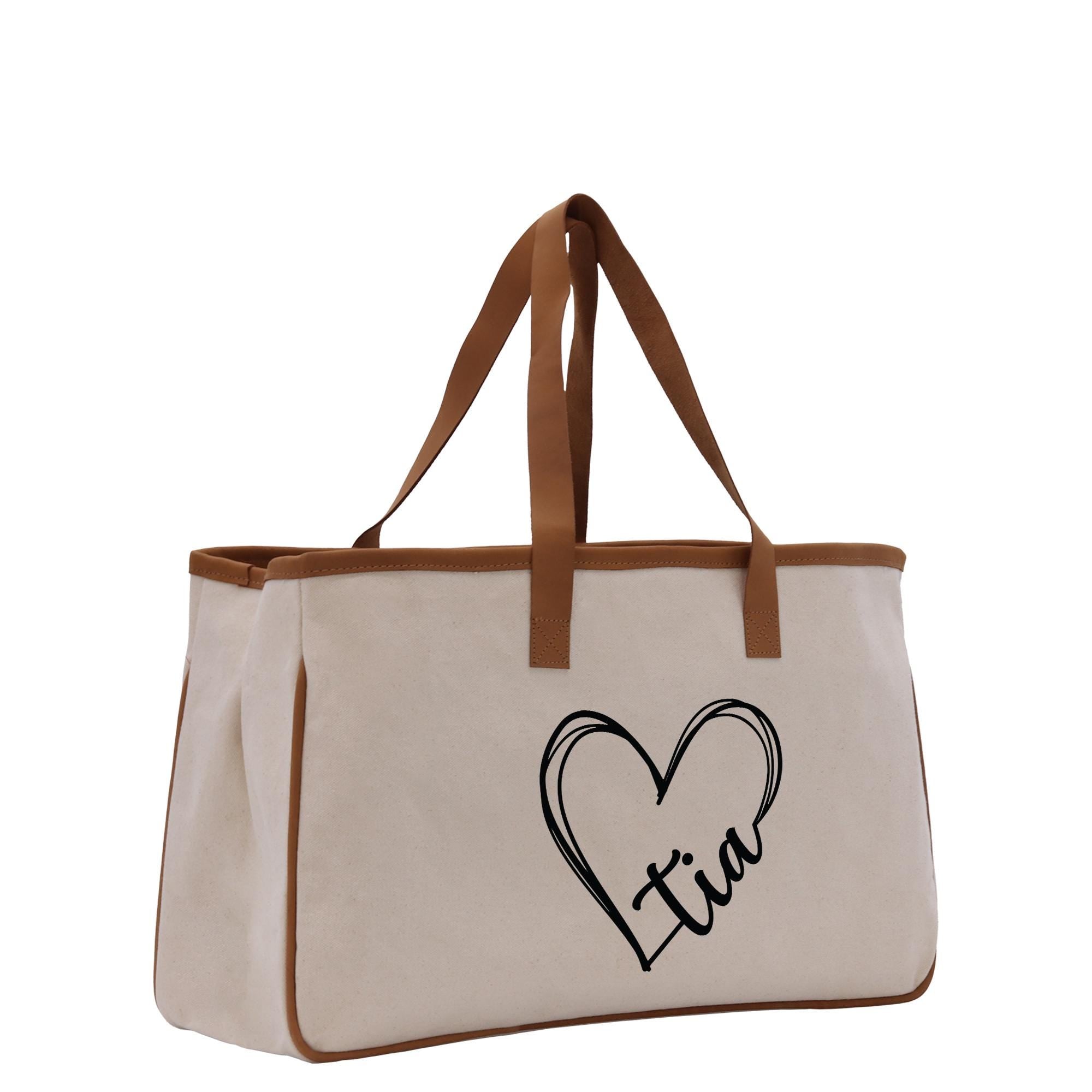 a white canvas bag with a brown leather handle