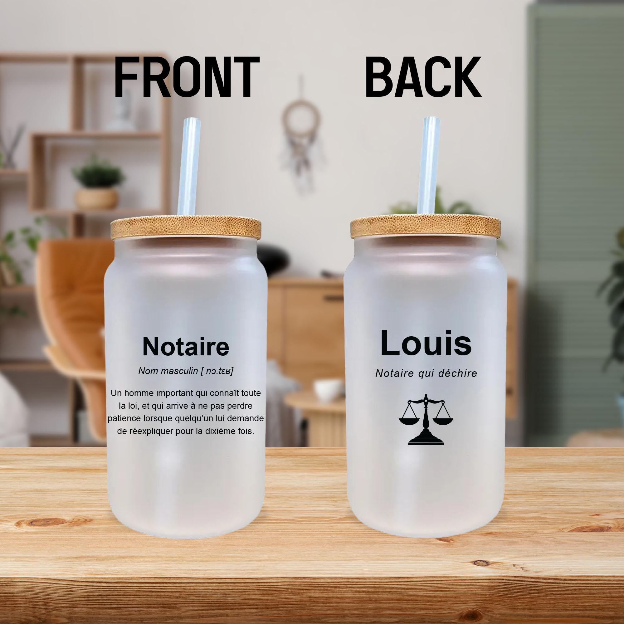 two identical glass jars with wooden lids, each containing a straw. The jars are placed on a wooden surface, and there are some plants in the background.