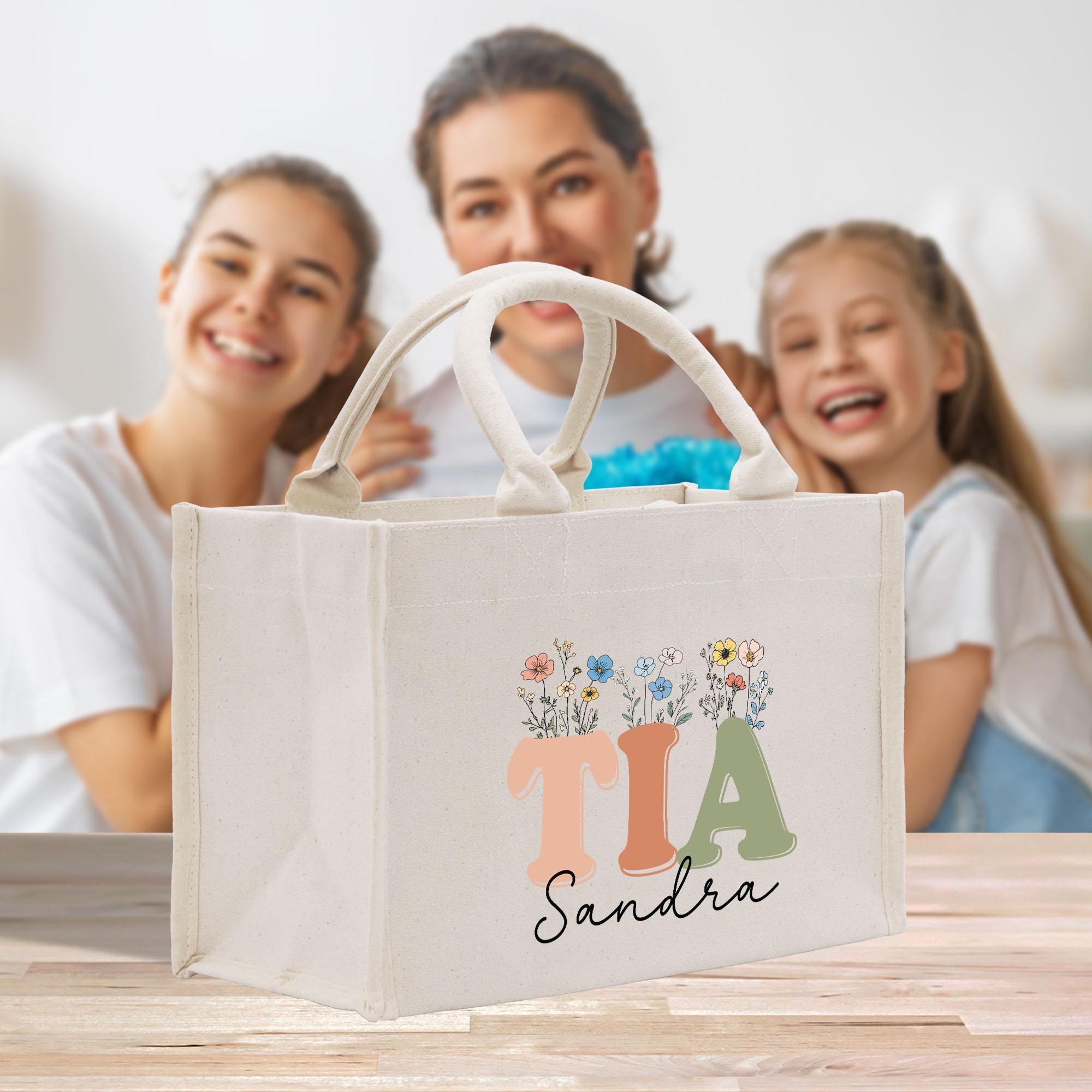 a woman and two girls sitting at a table with a bag