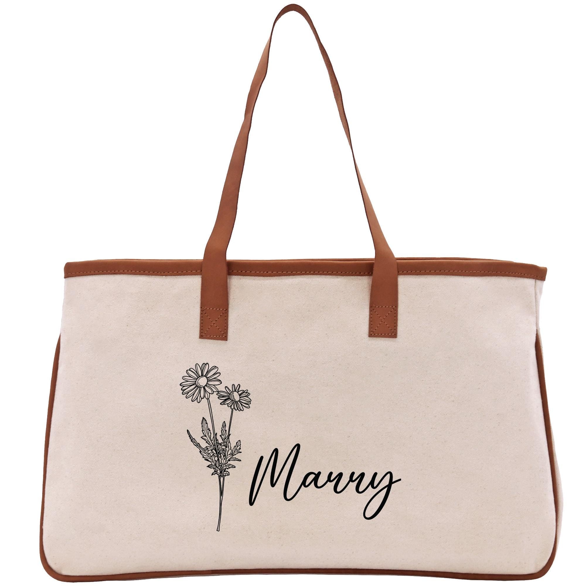 A beige canvas tote bag with a brown leather strap and a floral design printed on it.