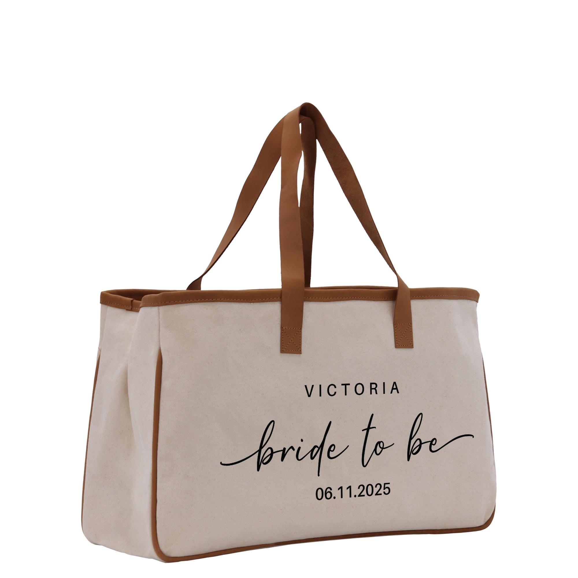 a white canvas tote bag with a brown leather handle