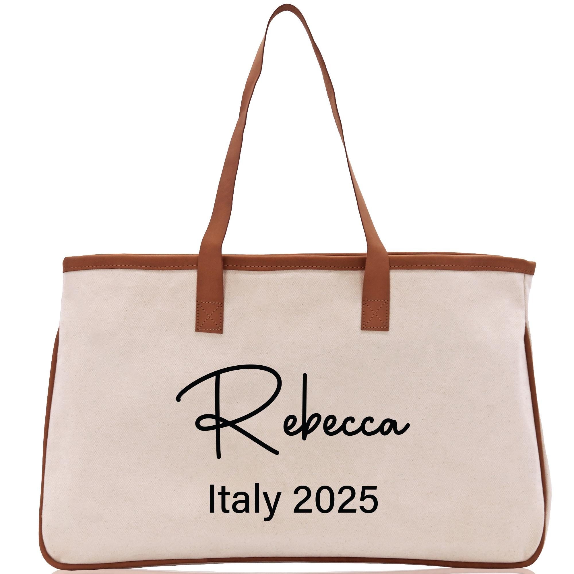 a white canvas bag with a brown leather handle