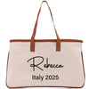 a white canvas bag with a brown leather handle