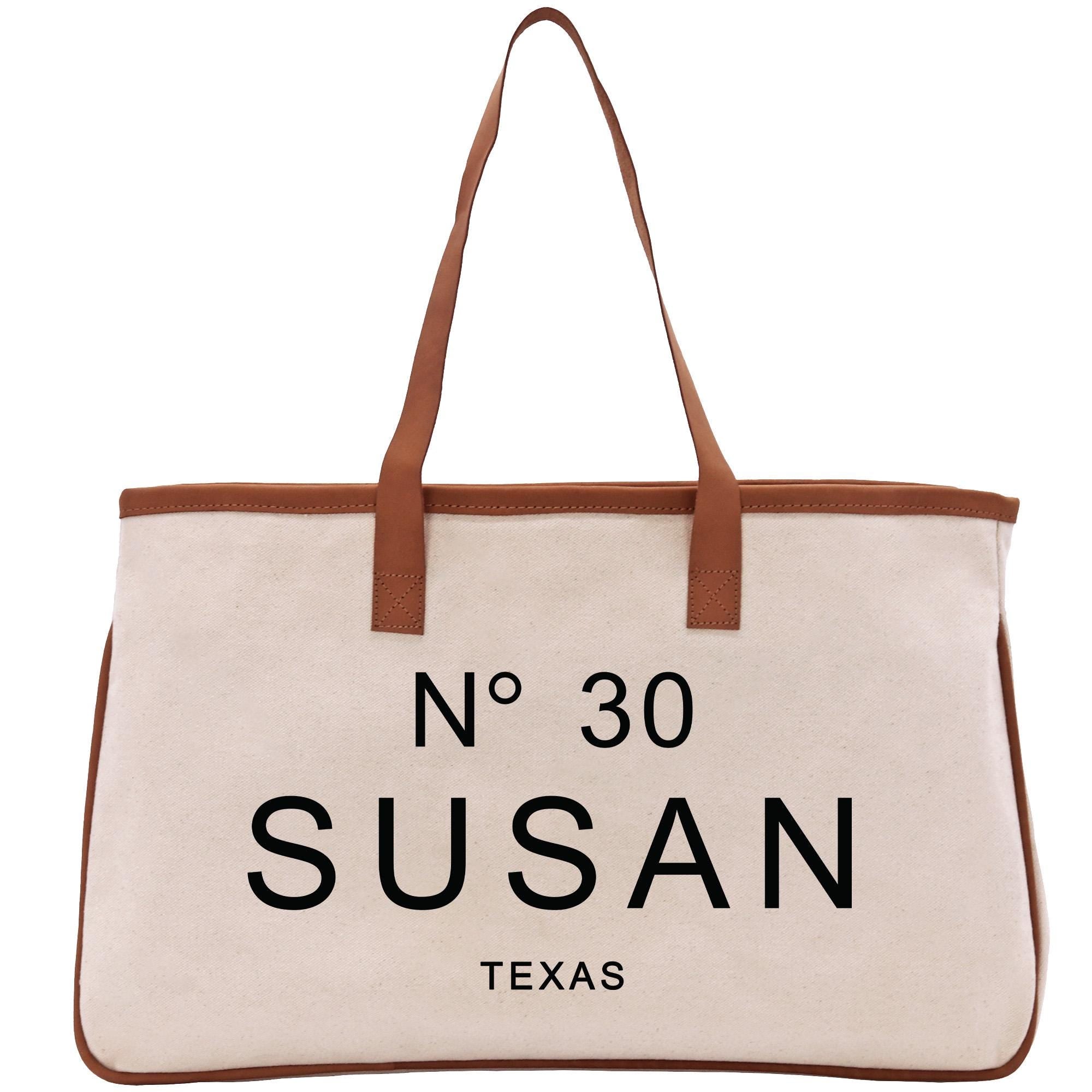 A beige tote bag with brown straps and the text &quot;N° 30 SUSAN TEXAS&quot; printed on it.