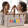 a couple of women sitting at a table with a bag