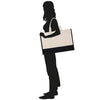 A silhouette of a woman holding a large bag.