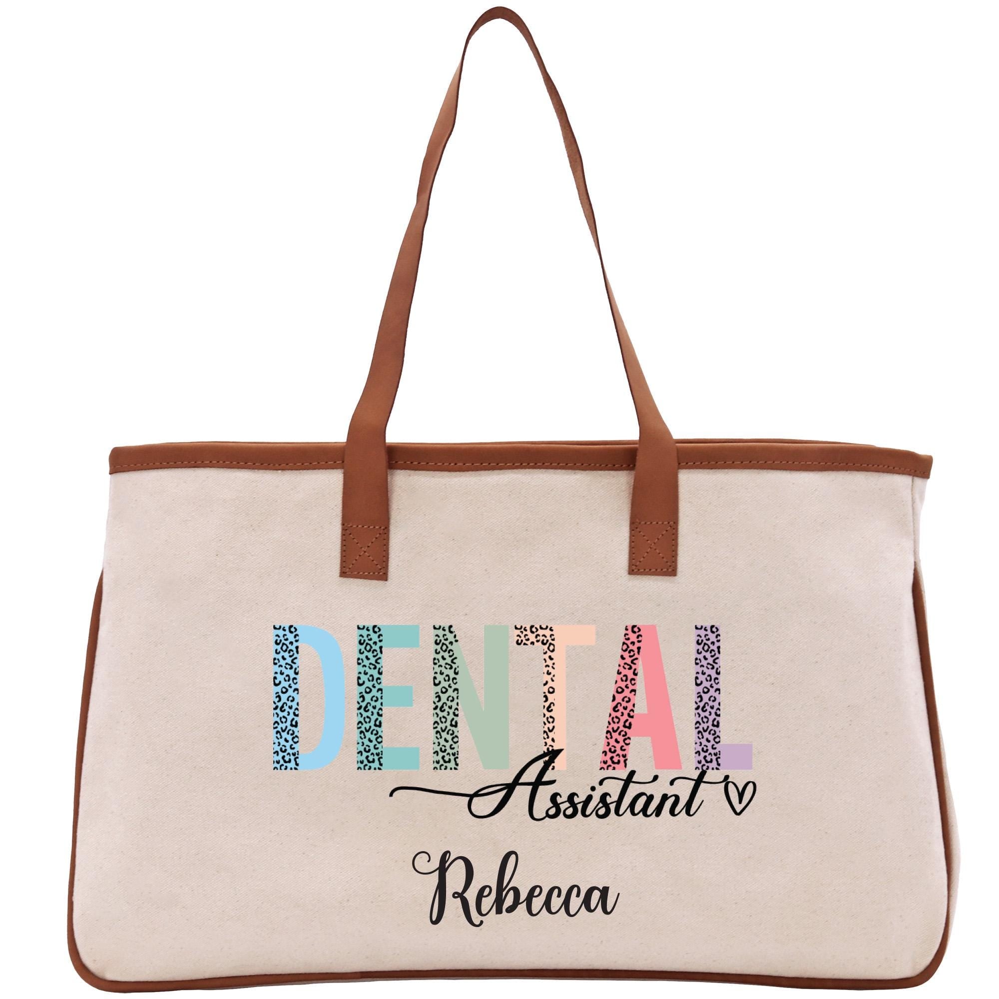 a white canvas bag with a brown leather handle