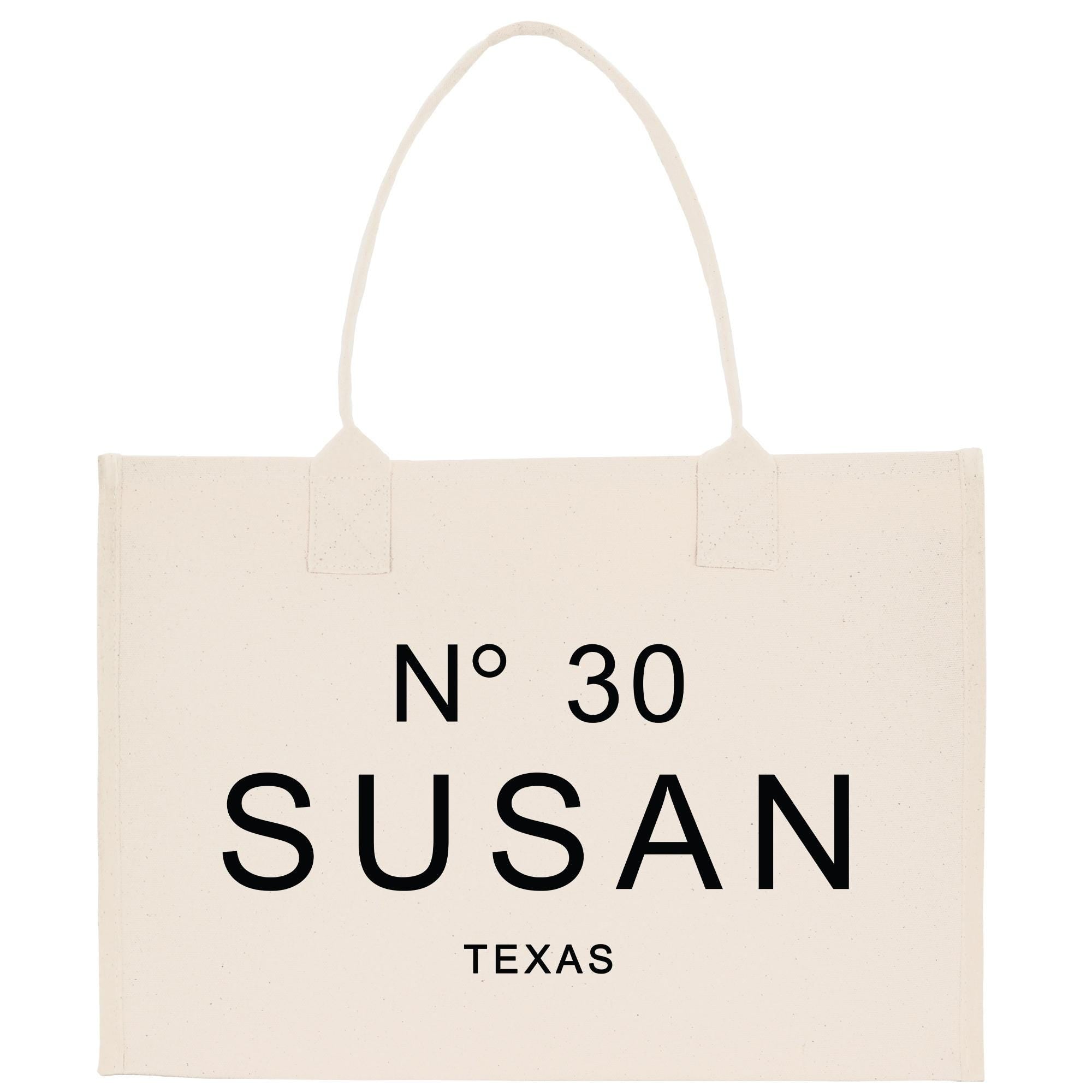 A beige tote bag with the text &quot;N° 30 SUSAN TEXAS&quot; printed on it.